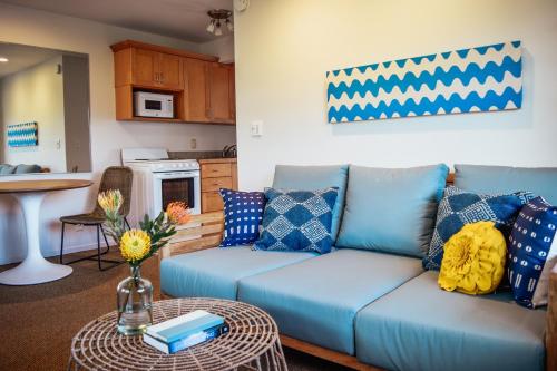 a living room with a blue couch and a table at Napili Village Hotel in Kahana