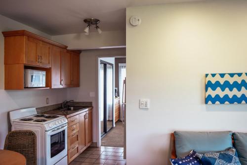 a kitchen with a white stove top oven next to a counter at Napili Village Hotel in Kahana