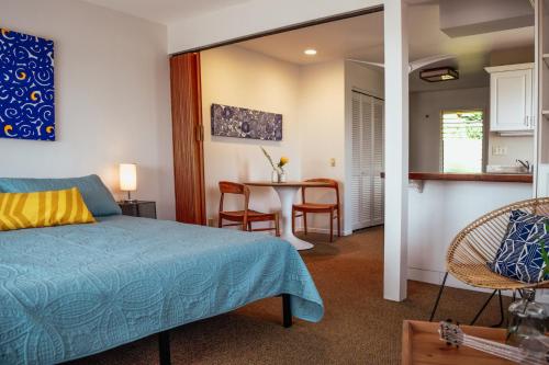 a bedroom with a bed and a table and chairs at Napili Village Hotel in Kahana