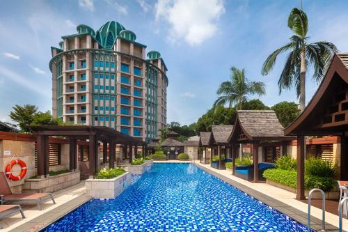 un hôtel avec une piscine et un grand bâtiment dans l'établissement Resorts World Sentosa - Crockfords Tower, à Singapour