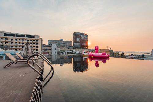 a swimming pool with a pink object in the water at Blackwoods Hotel Pattaya - SHA Extra Plus in Pattaya