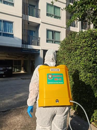 a person in a suit holding a yellow box at Interpark Hotel & Residence, Eastern Seaboard Rayong in Ban Phan Sadet Nok