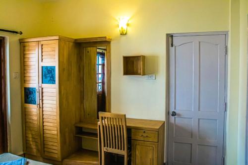 坎多林的住宿－Utopia Holiday Candolim，一间设有桌子、椅子和门的房间