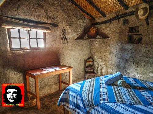 1 dormitorio con cama, mesa y ventana en Casa del Telegrafista en La Higuera
