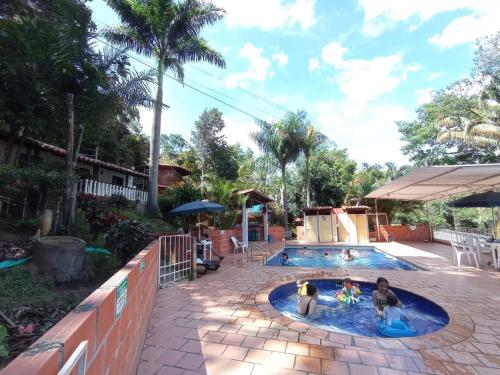 a family playing in a swimming pool at Cabañas Balconcitos in San Gil