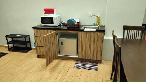 una cucina con lavello e forno a microonde su un bancone di Bangi Gateway Suite a Kampong Sungai Merab