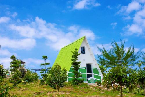 a house with a green roof on a hill at Durian Ecolodge in Tampin