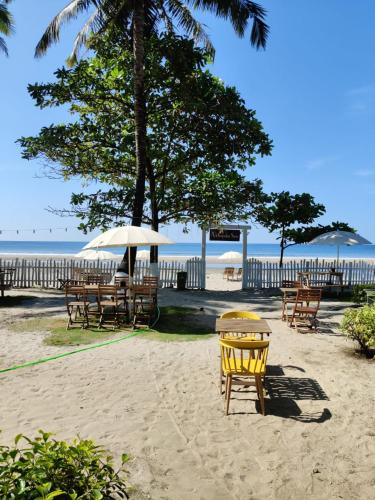 a group of tables and chairs on the beach at Buena Vida Beach Resort in Morjim