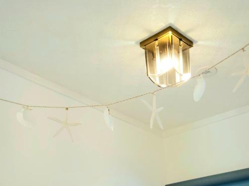 a light hanging from a ceiling with stars on it at "沖縄の美ら海をイメージしたコンセプトルーム&スマートハウス, 人気のリゾートタウン北谷で暮らすように過ごす, ゆったり64平米2LDK" Villa Blu Okinawa Chatan 2-1 ヴィラブルー沖縄北谷2-1 in Chatan