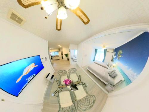 a living room with a fish tank on the wall at "沖縄の美ら海をイメージしたコンセプトルーム&スマートハウス, 人気のリゾートタウン北谷で暮らすように過ごす, ゆったり64平米2LDK" Villa Blu Okinawa Chatan 2-1 ヴィラブルー沖縄北谷2-1 in Chatan