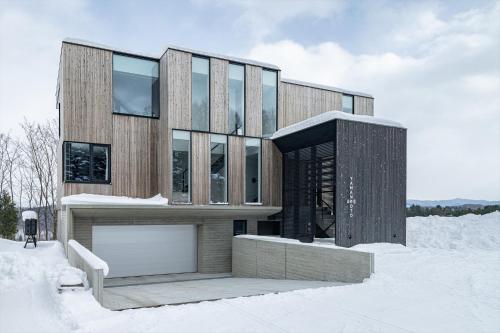 a wooden house in the snow in the snow at Yama no Oto in Furano