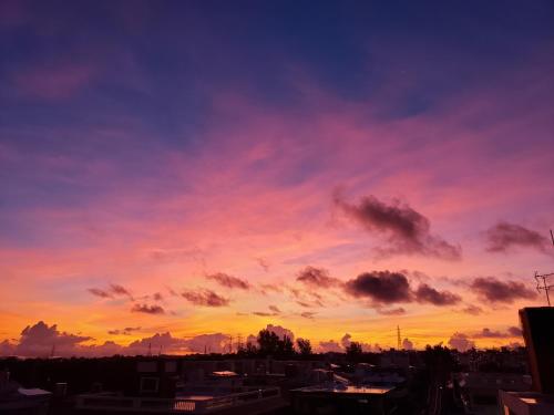 a sunset in a city with a pink at "沖縄の美ら海をイメージしたコンセプトルーム&スマートハウス, 人気のリゾートタウン北谷で暮らすように過ごす, ゆったり64平米2LDK" Villa Blu Okinawa Chatan 2-1 ヴィラブルー沖縄北谷2-1 in Chatan