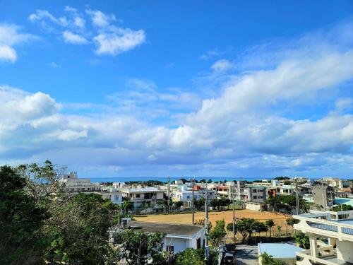 a city with buildings and a blue sky with clouds at "沖縄の美ら海をイメージしたコンセプトルーム, 100インチスクリーン&,プロジェクターで映画三昧!, ゆったり64平米2LDK" Villa Blu Okinawa Chatan 3-3 ヴィラブルー沖縄北谷3-3 in Chatan