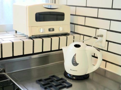 a coffee maker on a counter next to a microwave at "沖縄の美ら海をイメージしたコンセプトルーム, 100インチスクリーン&,プロジェクターで映画三昧!, ゆったり64平米2LDK" Villa Blu Okinawa Chatan 3-3 ヴィラブルー沖縄北谷3-3 in Chatan