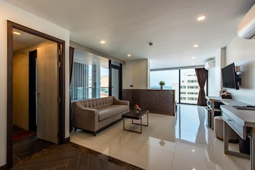 a living room with a couch and a desk at Blackwoods Hotel Pattaya - SHA Extra Plus in Pattaya