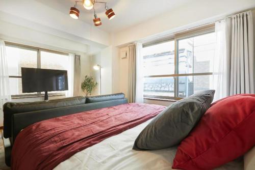 1 dormitorio con 1 cama con sofá y TV en HOTEL AIS HATAGAYA, en Tokio