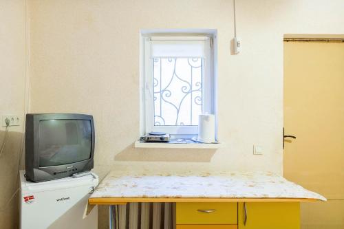 een tv op een tafel naast een raam bij Уютная смарт-квартира возле моря, областной лечебницы и Куяльника in Odessa