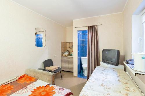 een kleine kamer met een bed en een televisie bij Уютная смарт-квартира возле моря, областной лечебницы и Куяльника in Odessa