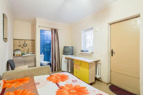 a small room with a kitchen and a desk with a table at Уютная смарт-квартира возле областной лечебницы, моря и Куяльника in Odesa