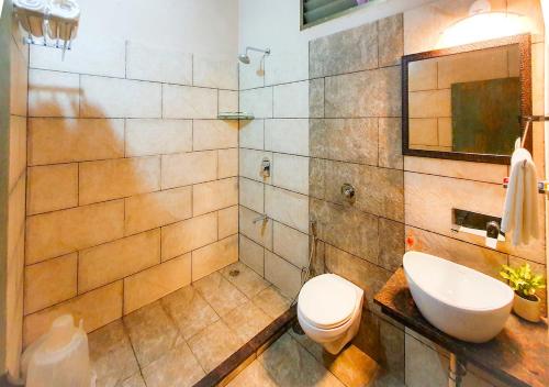 a bathroom with a white toilet and a sink at The Satpura Panchtatva Villa in Khāpa