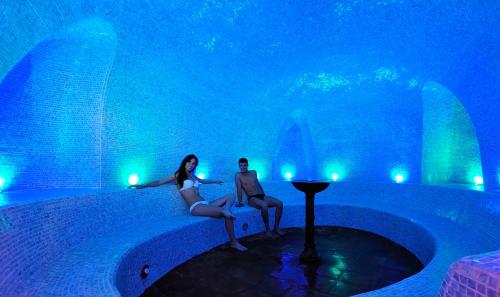 a man and a woman are in a swimming pool at Arbatax Park Resort - Telis in Àrbatax
