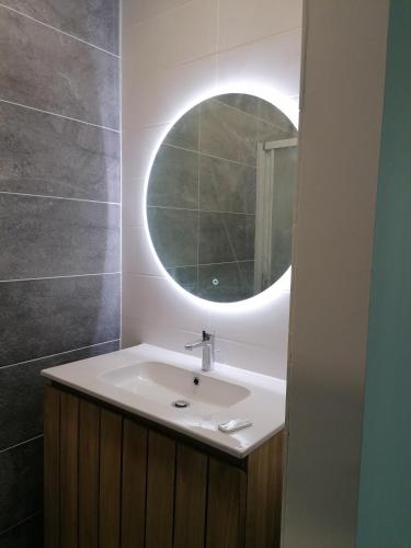 une salle de bain avec un lavabo blanc et un miroir dans l'établissement SETE VUE EXCEPTIONNELLE, à Sète