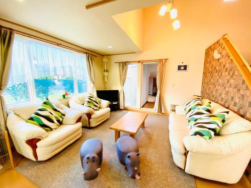 a living room with two couches and two stuffed animals at Ecco's House エッコズハウス in Shiraoi