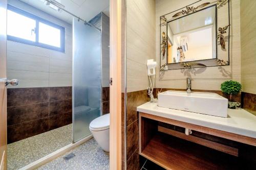 La salle de bains est pourvue d'un lavabo, de toilettes et d'un miroir. dans l'établissement Aurora Castle, à Luodong