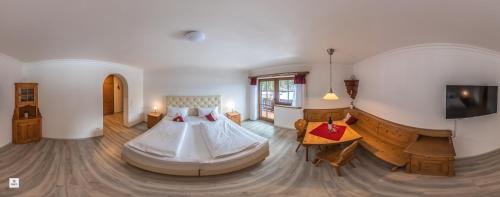 a bedroom with a bed and a tv in it at Landhotel Lärchenhügel in Oberammergau