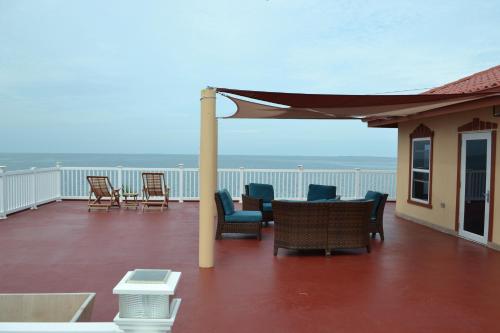 a patio with chairs and tables on a deck at Belizean Nirvana in Placencia Village