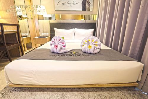 a bedroom with a bed with two towels on it at Menteng Park Exclusive Emerald in Jakarta