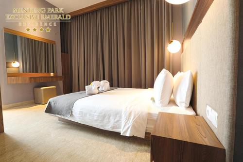 a hotel room with a bed with two pillows on it at Menteng Park Exclusive Emerald in Jakarta