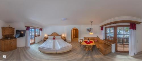 a bedroom with a bed and a living room at Landhotel Lärchenhügel in Oberammergau