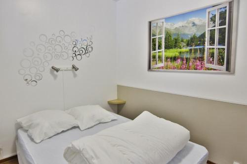 1 dormitorio con cama y ventana en Résidence des Jardins, wifi en Luchon
