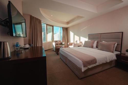 a hotel room with a large bed and a television at Mihrako Hotel & Spa in As Sulaymānīyah