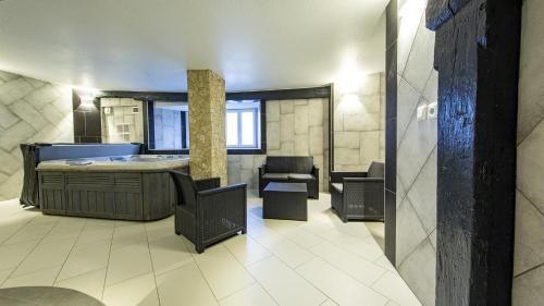 a bathroom with a tub and chairs in a room at Domaine de l'Atelier in Soultzmatt