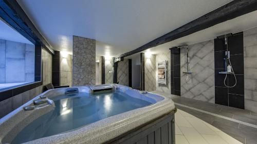 a large bathroom with a tub and a shower at Domaine de l'Atelier in Soultzmatt