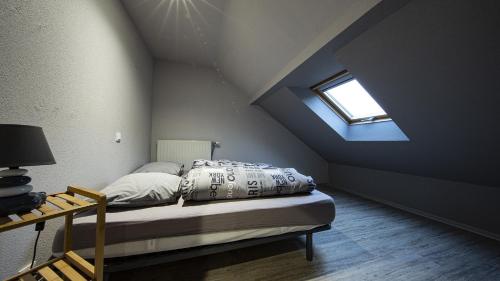 a bedroom with a bed with a blue ceiling and a window at Domaine de l'Atelier in Soultzmatt