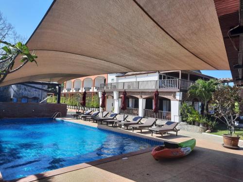 een zwembad met ligstoelen naast een gebouw bij Palm Beach Resort in Pran Buri