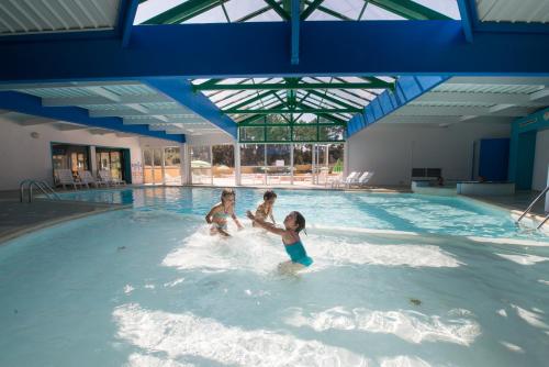 3 enfants jouant dans une piscine dans l'établissement Le Domaine des Pins, à Saint-Hilaire-de-Riez