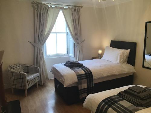 1 dormitorio con 2 camas y ventana en Number One, en Haddington