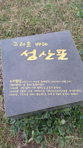 a stone sign with writing on it in the grass at Hotel HueStay-KeumHo in Seogwipo