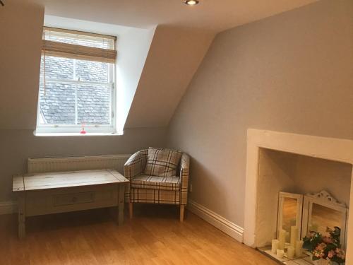 a living room with a chair and a fireplace at Number One in Haddington