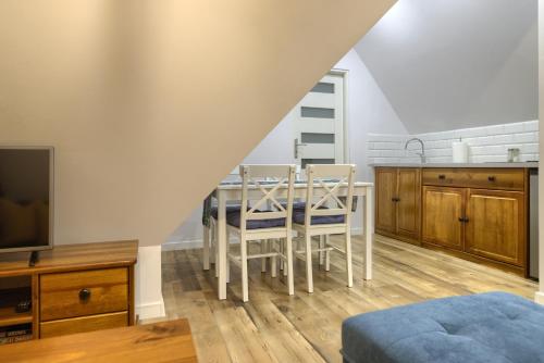 a kitchen with a table and chairs in a room at Apartament na Szczycie in Bukowina Tatrzańska