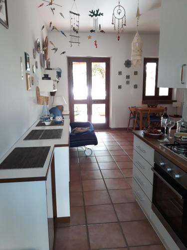 eine Küche mit weißen Schränken und Fliesenboden in der Unterkunft CASINA PONENTE in Macari