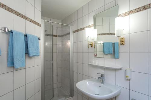 a white bathroom with a sink and a shower at Hotel-Gasthaus Engel Luttingen in Laufenburg