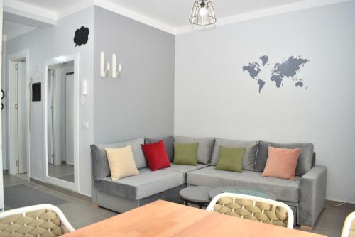 uma sala de estar com um sofá cinzento com almofadas coloridas em Wide Beach Apartment - 236 em Durrës