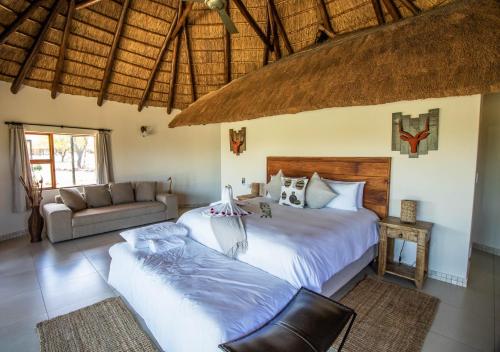 Un dormitorio con una cama grande y un sofá. en Golden Impalas Bush Resort, en Hammanskraal