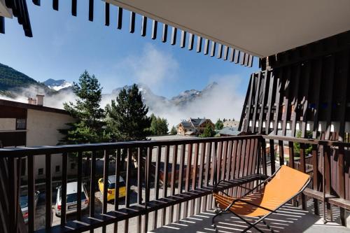 a chair on a balcony with a view of a mountain at Vacancéole - Résidence Quirlies in Les Deux Alpes