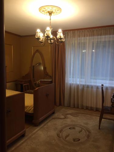 a bedroom with a bed and a mirror and a chandelier at Villa Moderna in Jūrmala